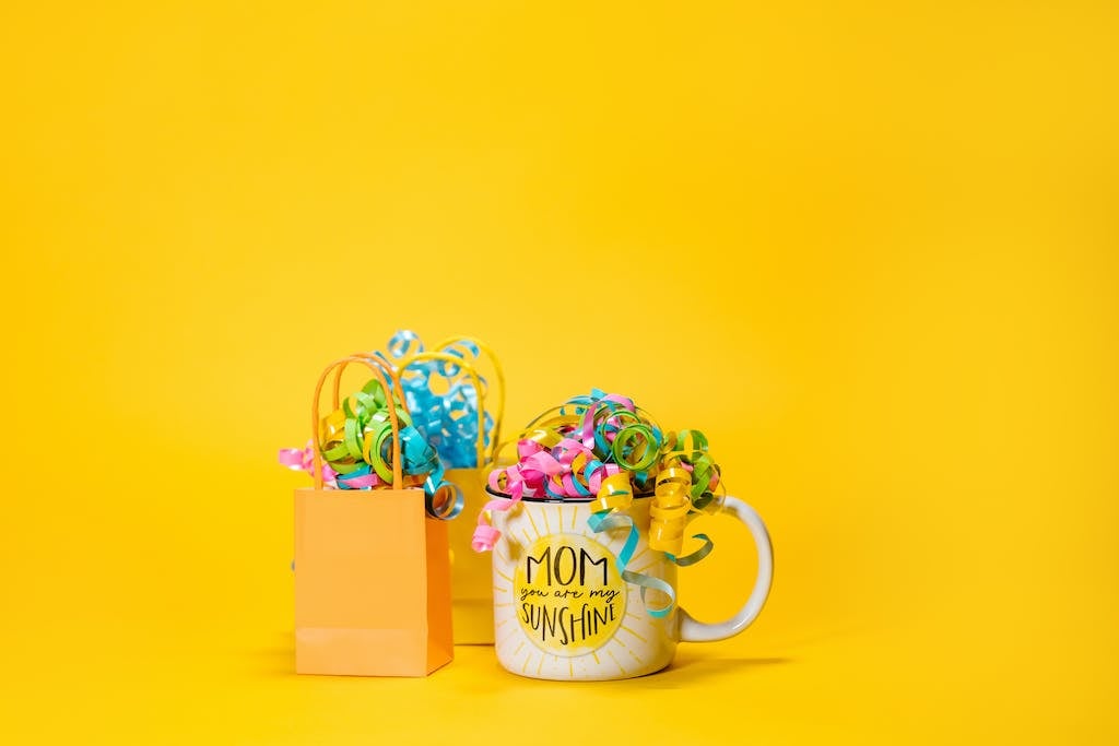 A Mug beside Paper Bags with Decorative Ribbons